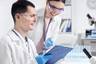 Scientists working with laboratory test form at table indoors