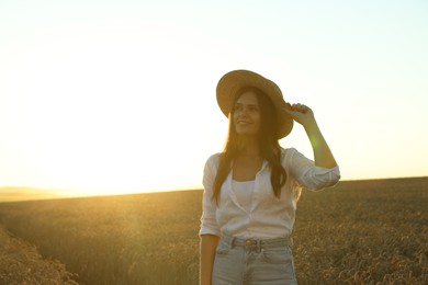Photo of Beautiful young woman in ripe wheat field on sunny day, space for text