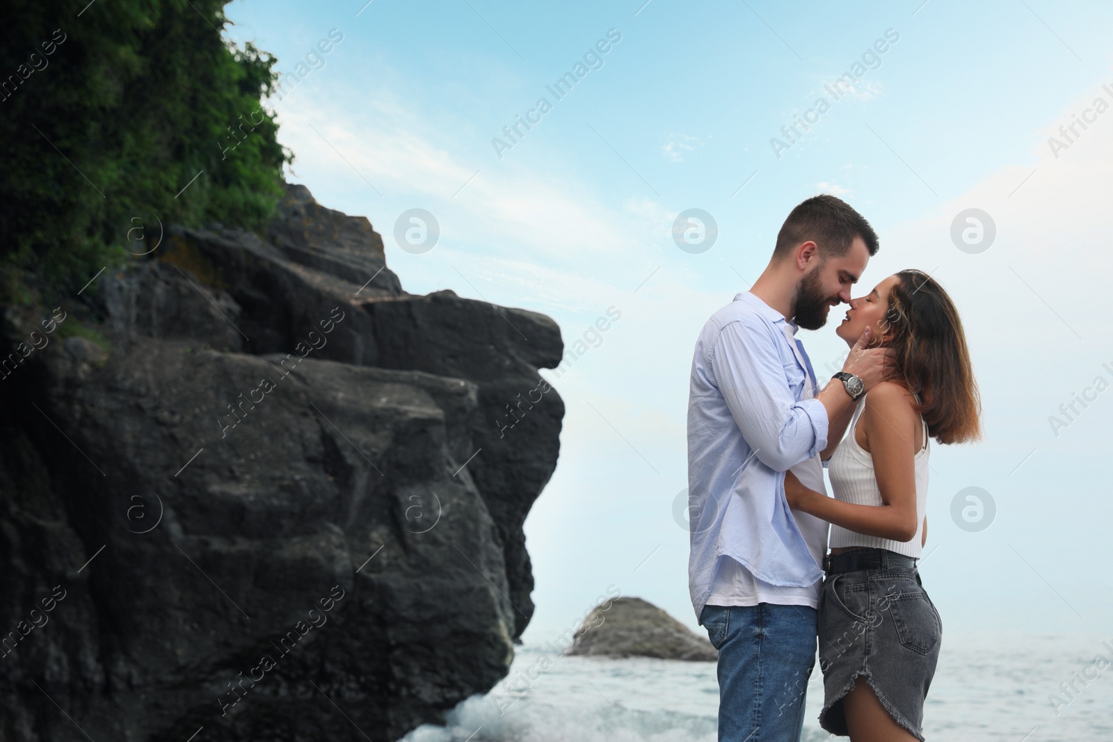 Photo of Young couple spending time together near sea. Space for text