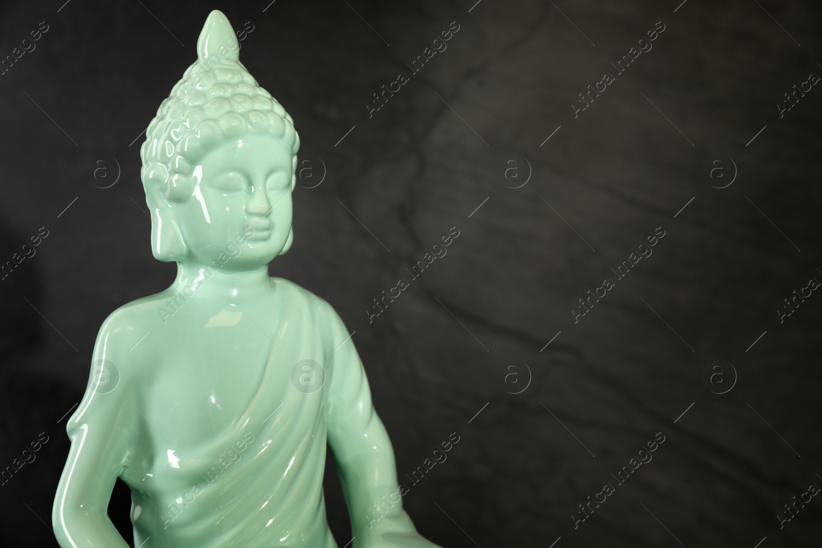 Photo of Buddha statue on dark background, closeup. Space for text