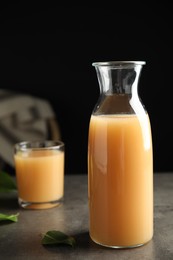 Photo of Fresh pear juice in glass bottle on grey table