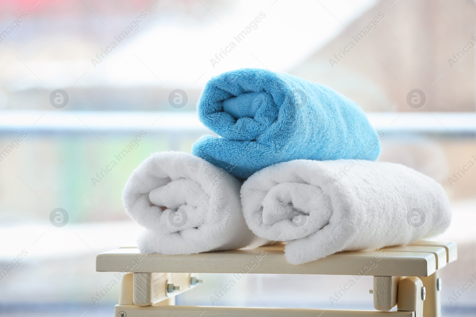 Photo of Rolled towels on table against blurred background