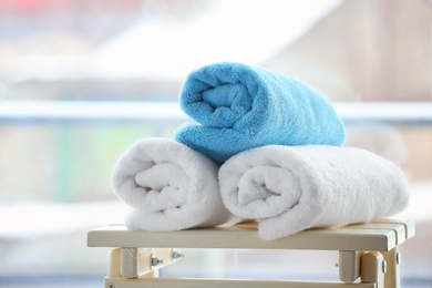 Photo of Rolled towels on table against blurred background