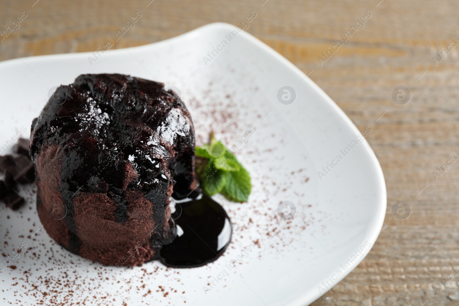 Photo of Delicious warm chocolate lava cake on plate, closeup