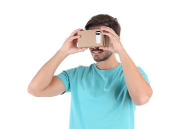 Young man using cardboard virtual reality headset, isolated on white