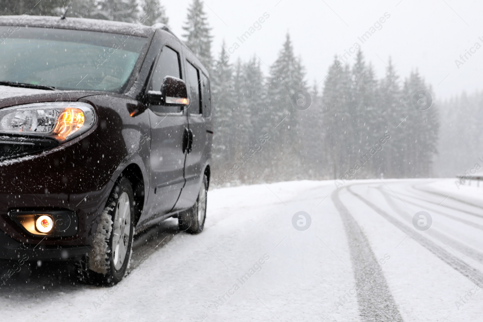 Photo of Country road with car on snowy winter day. Space for text