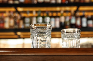 Photo of Empty clean glasses on counter in modern bar, low angle view