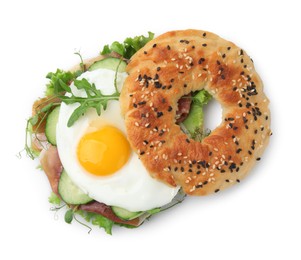 Tasty bagel with cured ham, egg, cucumber and salad mix isolated on white, top view