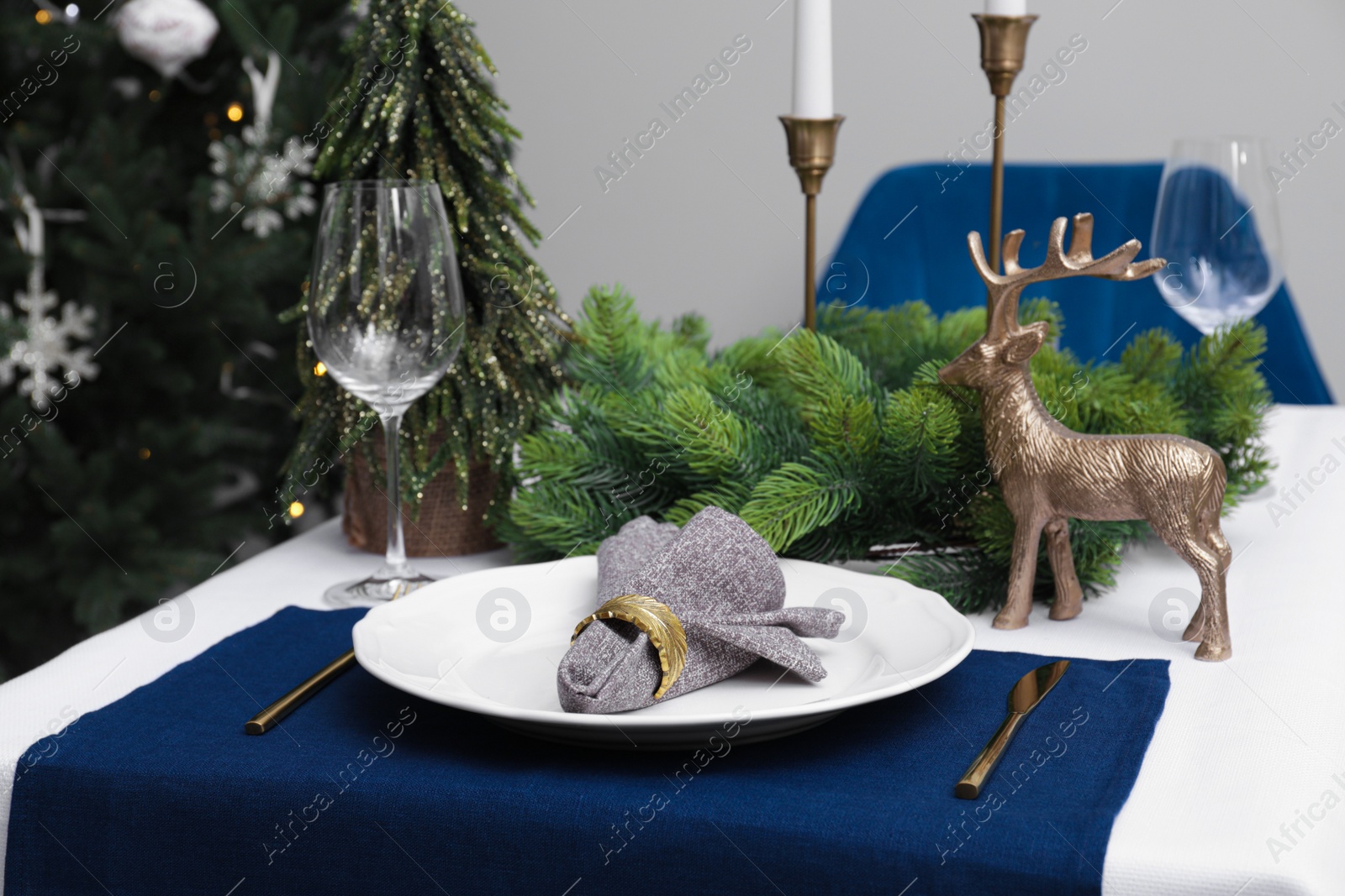 Photo of Festive place setting with beautiful dishware, cutlery and fabric napkin for Christmas dinner on white table