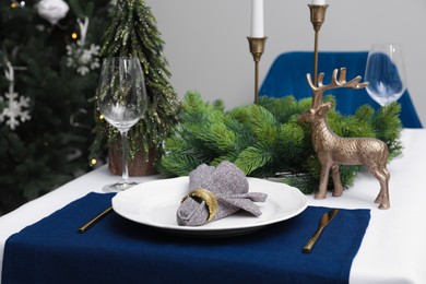 Photo of Festive place setting with beautiful dishware, cutlery and fabric napkin for Christmas dinner on white table