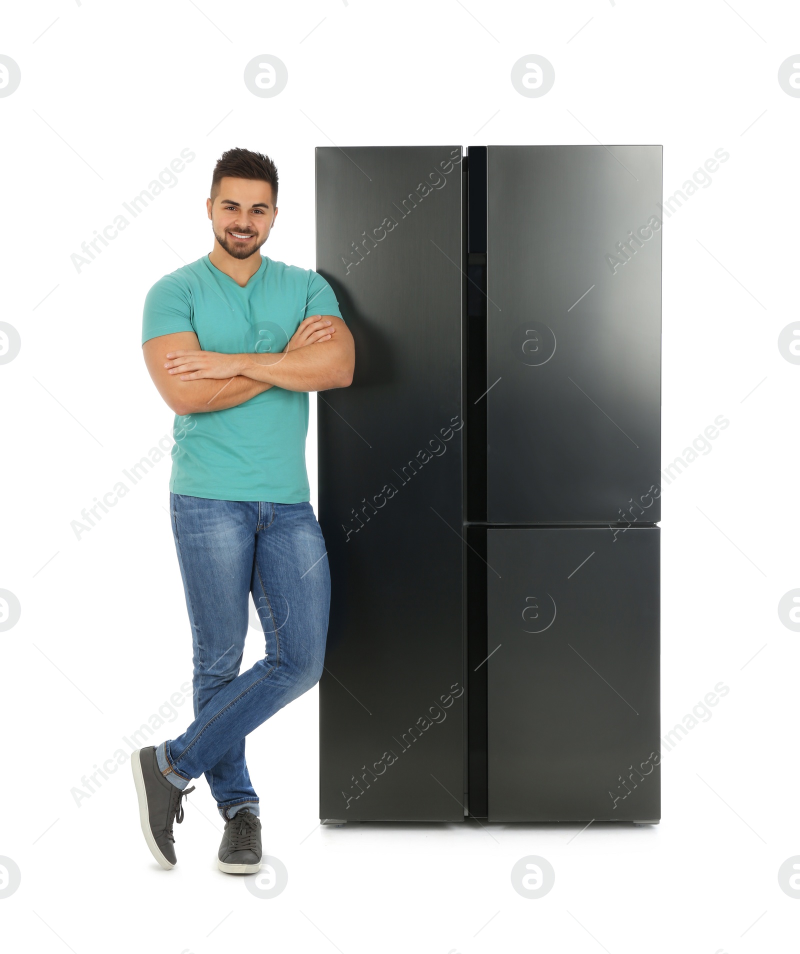 Photo of Young man near refrigerator on white background