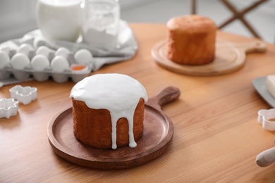 Photo of Traditional Easter cake and ingredients on wooden table indoors