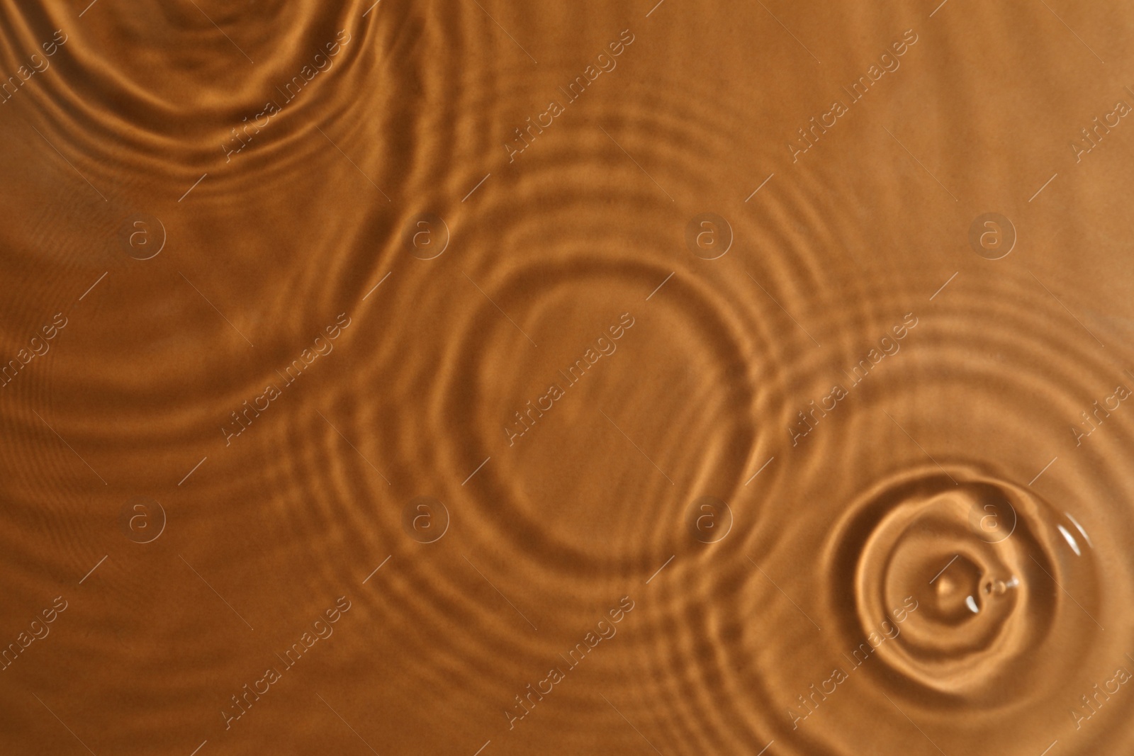 Photo of Closeup view of water with circles on brown background