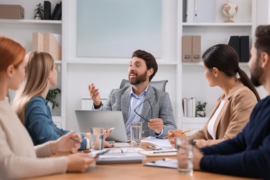 Photo of Team of employees working together in office