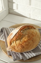 Photo of Freshly baked sourdough bread on white wooden table indoors