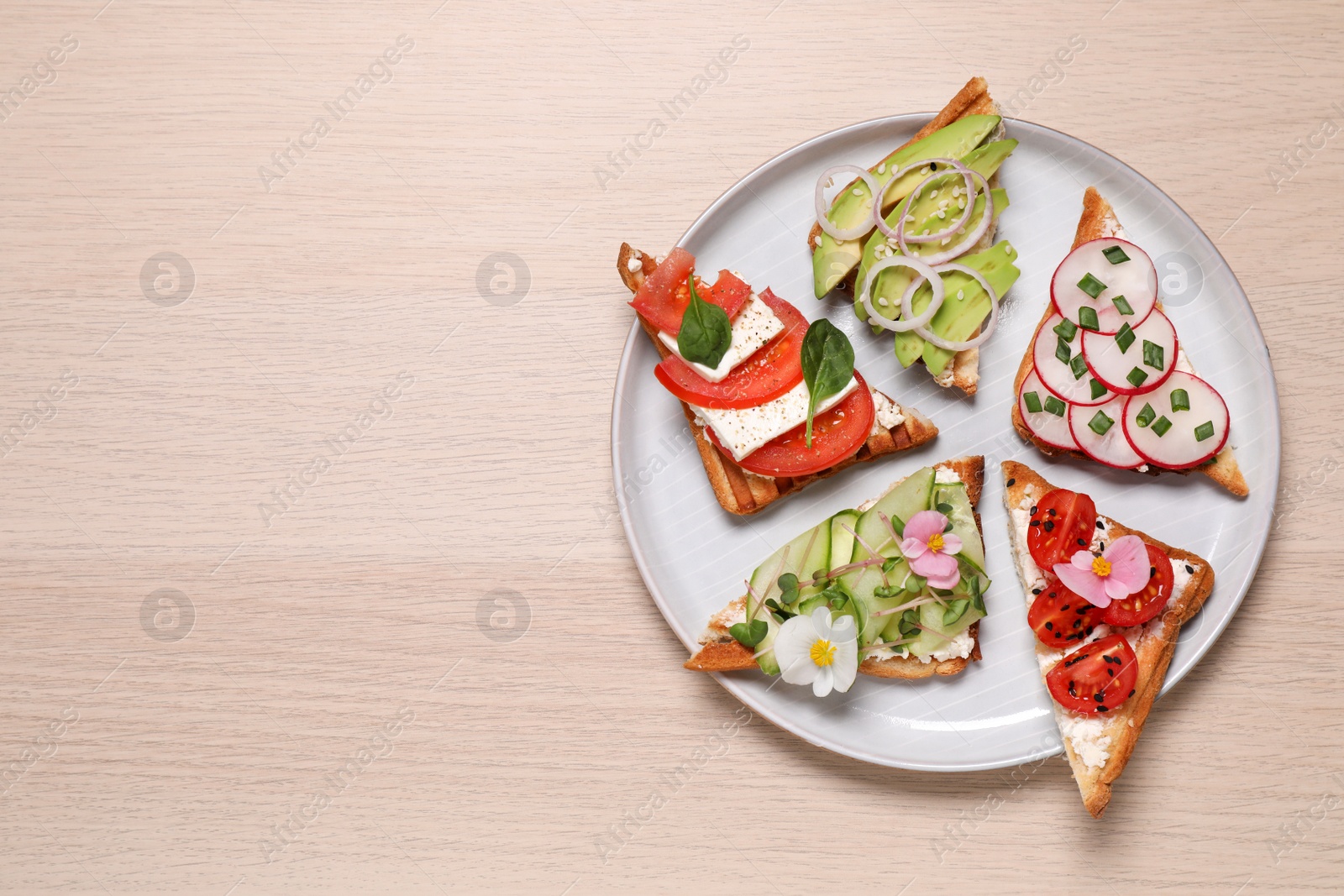 Photo of Different tasty sandwiches served on wooden table, top view. Space for text