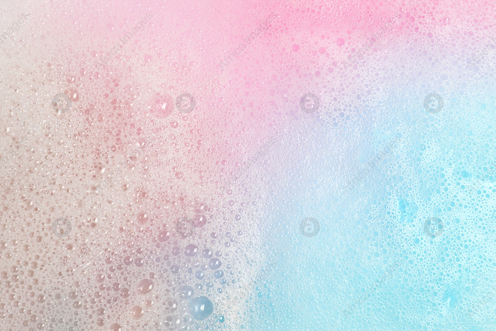 Photo of Colorful foam after dissolving bath bomb in water, closeup