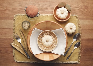 Photo of Autumn table setting with pumpkins and decor on wooden background, flat lay