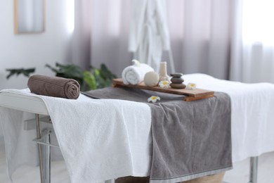 Photo of Rolled towel and spa products on massage table in recreational center