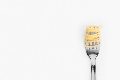 Fork with tasty pasta on white background, top view. Space for text