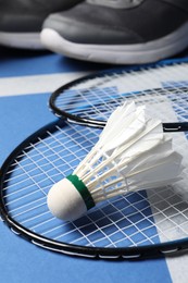 Photo of Feather badminton shuttlecock and rackets on court, closeup