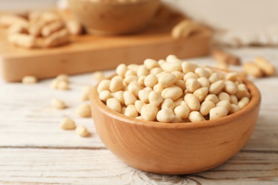 Shelled peanuts in wooden bowl on table