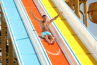 Man on slide at water park. Summer vacation