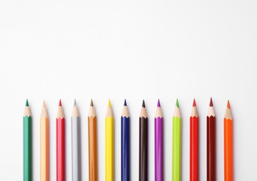 Colorful wooden pencils on white background, flat lay. Space for text