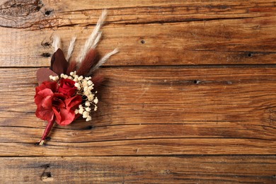 Photo of Beautiful boutonniere on wooden background, top view. Space for text