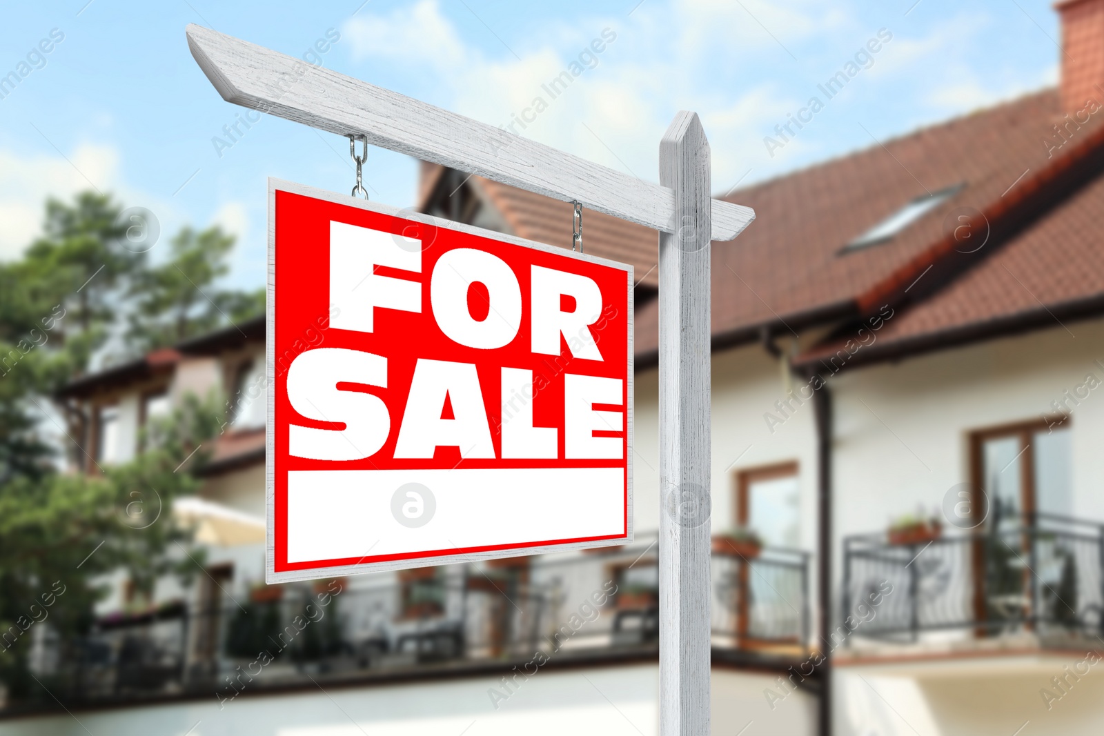 Image of Sale sign near beautiful house outdoors. Red signboard with words