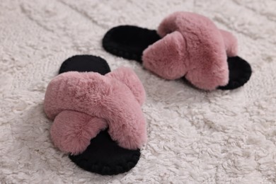 Photo of Colorful soft slippers on light carpet, closeup