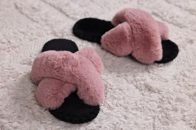 Colorful soft slippers on light carpet, closeup