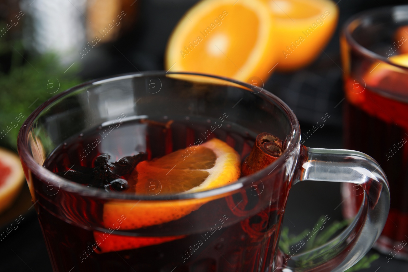 Photo of Tasty mulled wine in glass cup on table, closeup