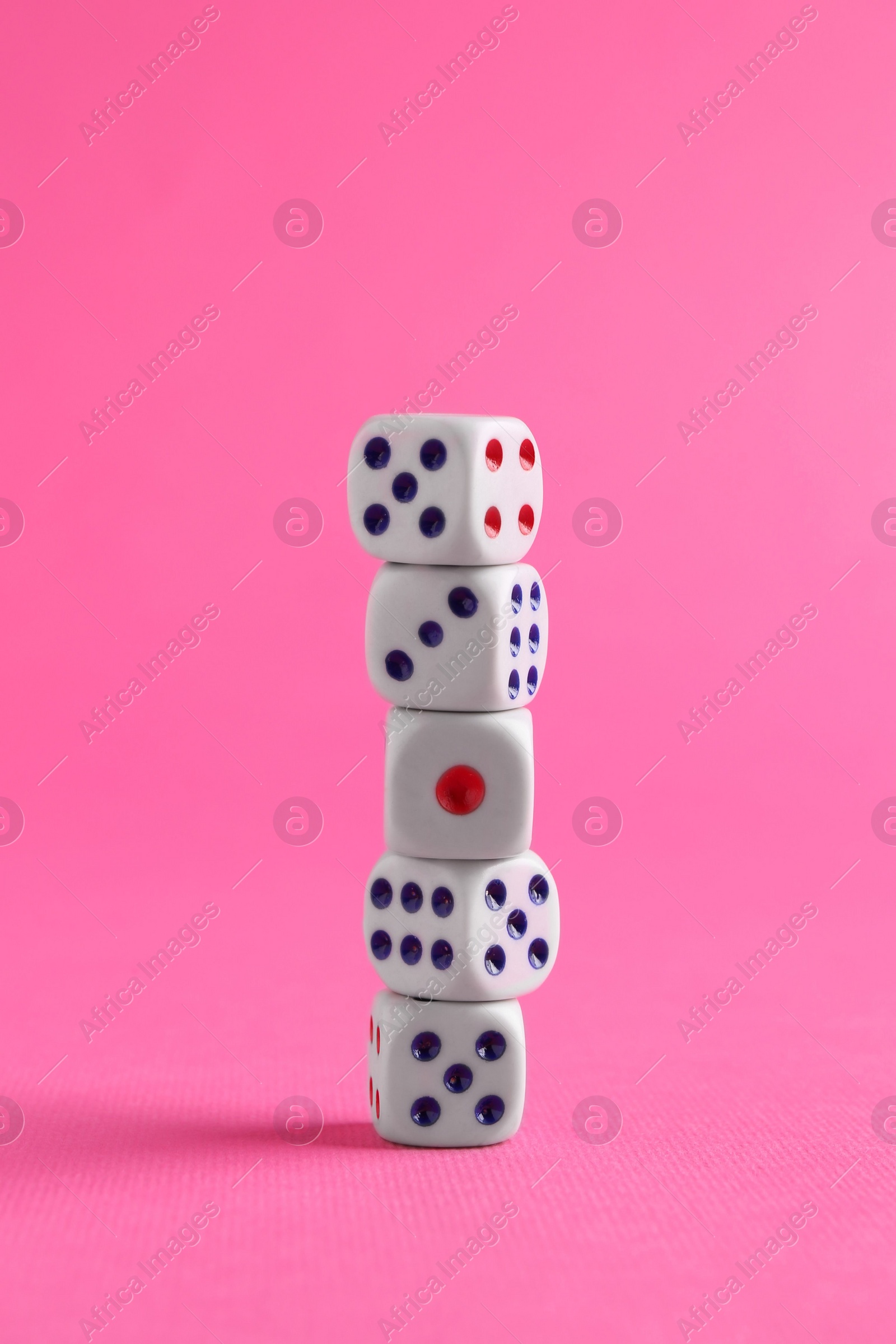 Photo of Many stacked game dices on pink background