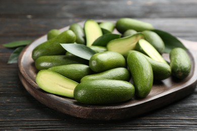 Photo of Fresh seedless avocados on dark wooden table, closeup