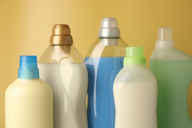 Photo of Bottles of fabric softener on yellow background