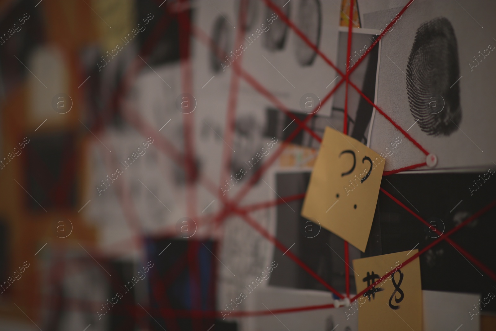 Photo of Detective board with sticker, fingerprints and red threads, closeup