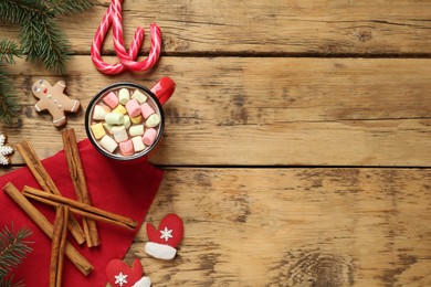 Delicious hot chocolate with marshmallows and gingerbread cookies on wooden table, flat lay. Space for text
