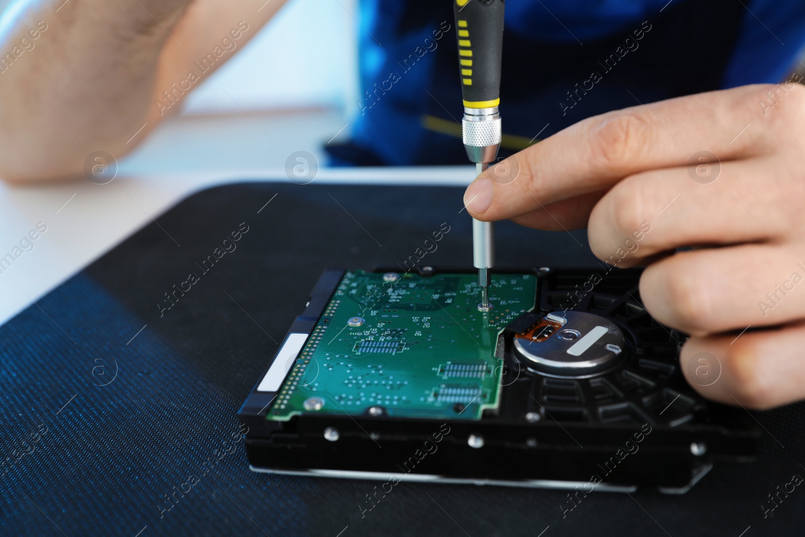 Photo of Male technician repairing hard drive at table, closeup. Space for text