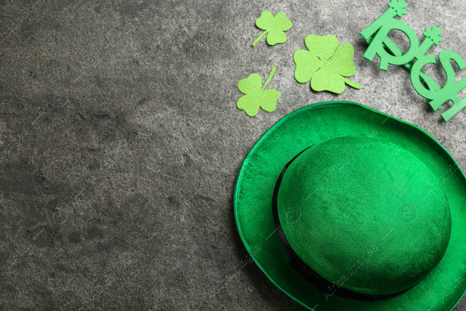 Photo of Leprechaun's hat and St. Patrick's day decor on grey stone background, flat lay. Space for text