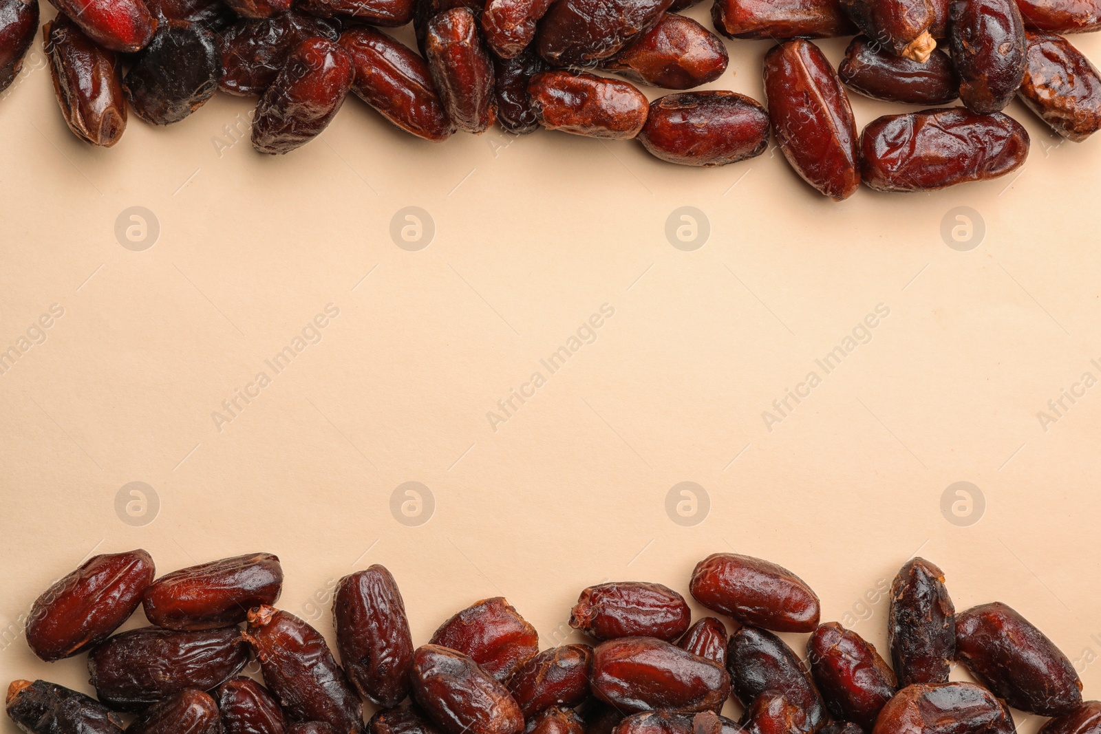 Photo of Frame made of sweet dried date fruits on color background, top view with space for text