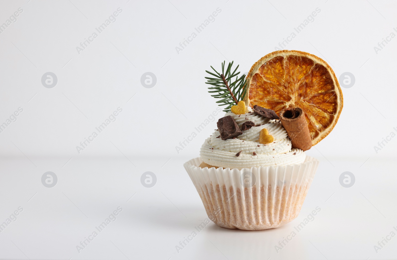 Photo of Tasty Christmas cupcake with cream and decor on white background, space for text