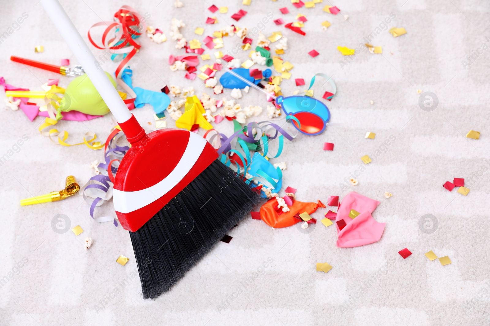 Photo of Sweeping trash after party with bristle broom indoors