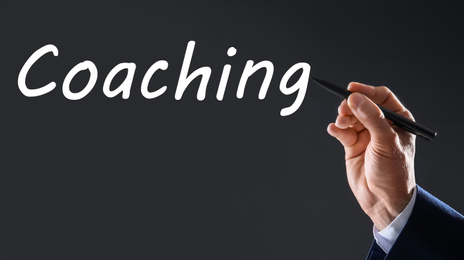 Image of Business trainer writing word Coaching on virtual screen, closeup. Banner design