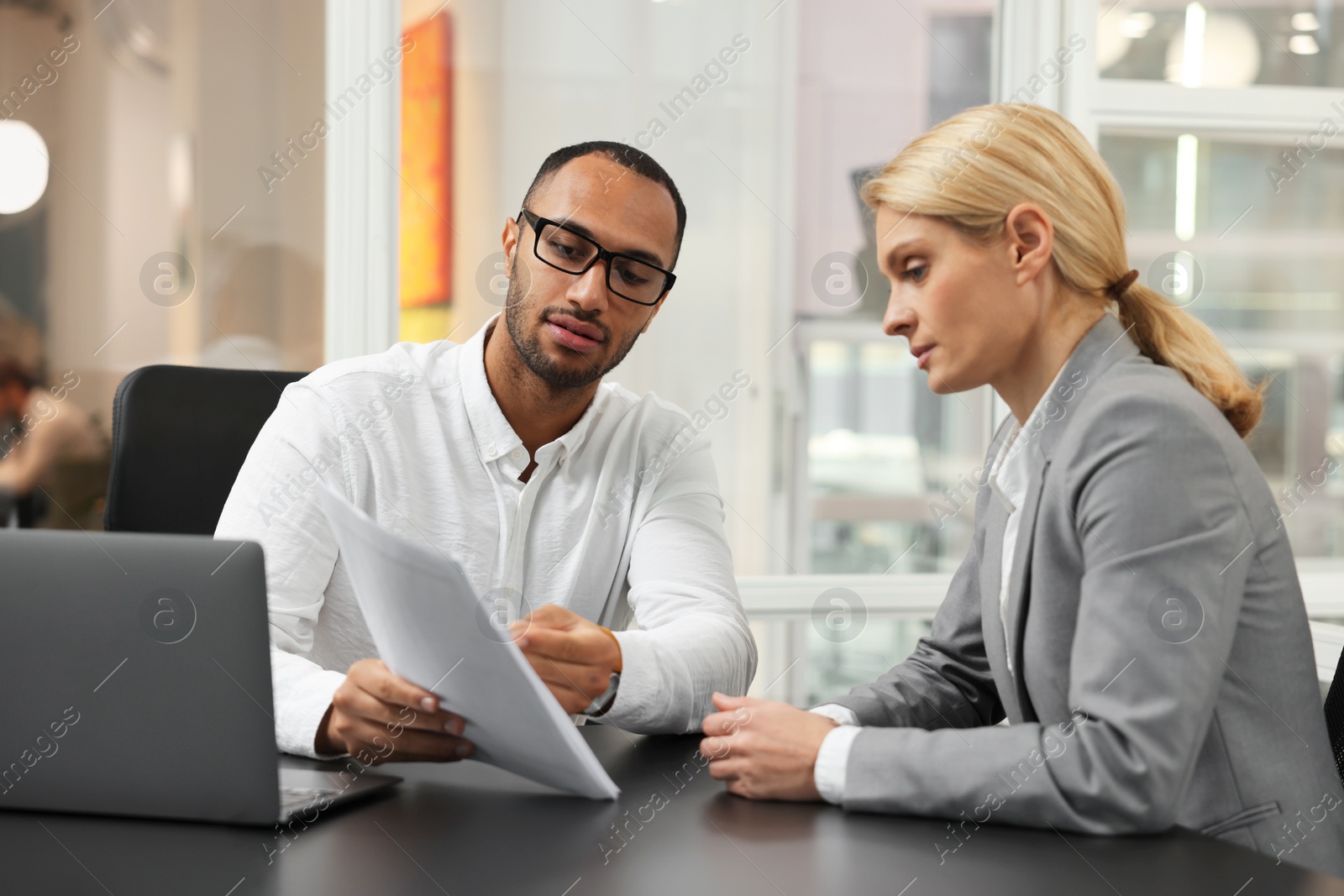 Photo of Lawyers working together with documents at table in office