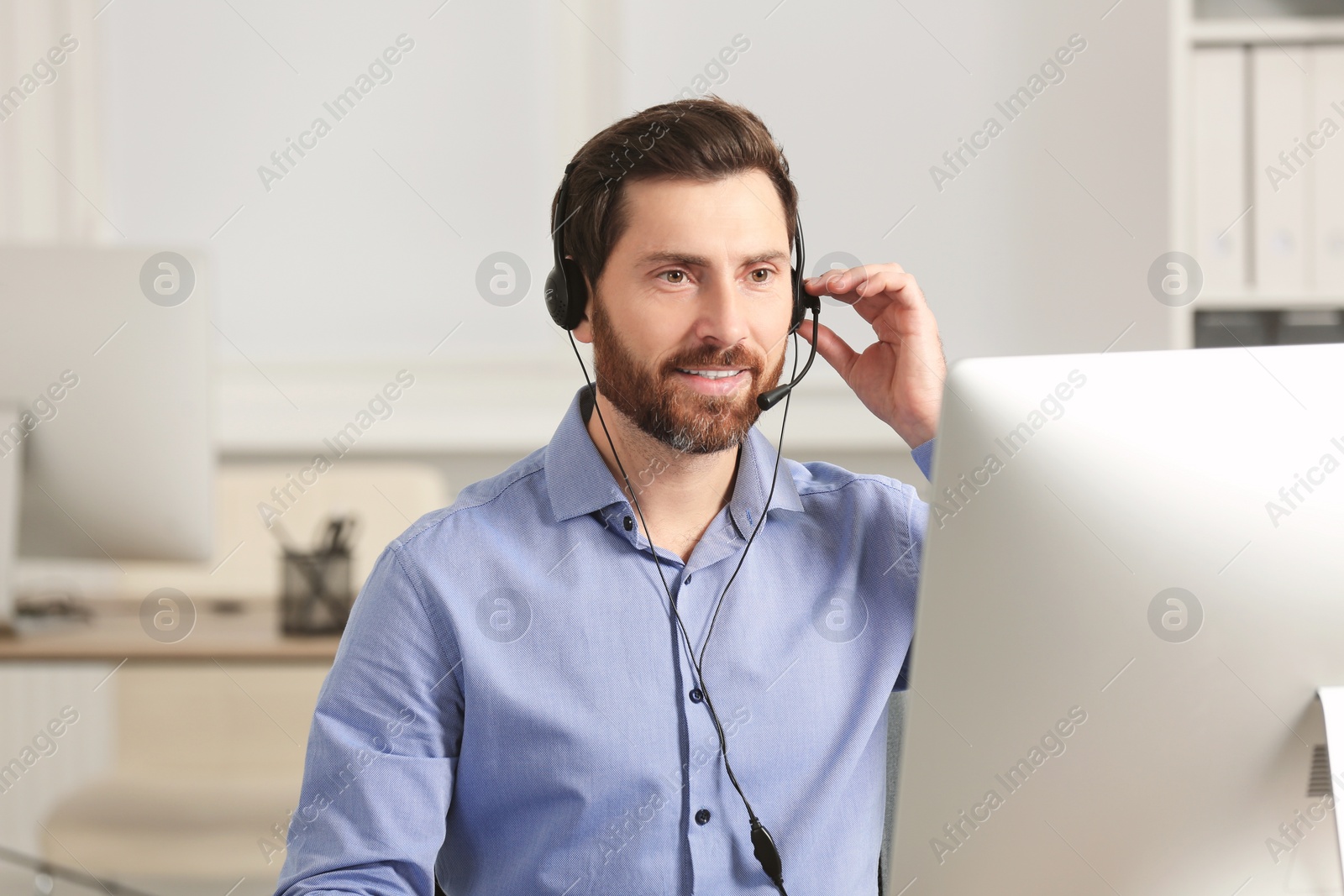 Photo of Hotline operator with headset working in office