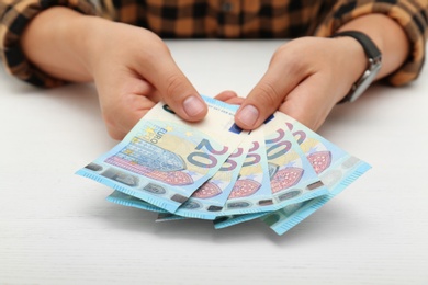 Photo of Man with Euro banknotes at table, closeup