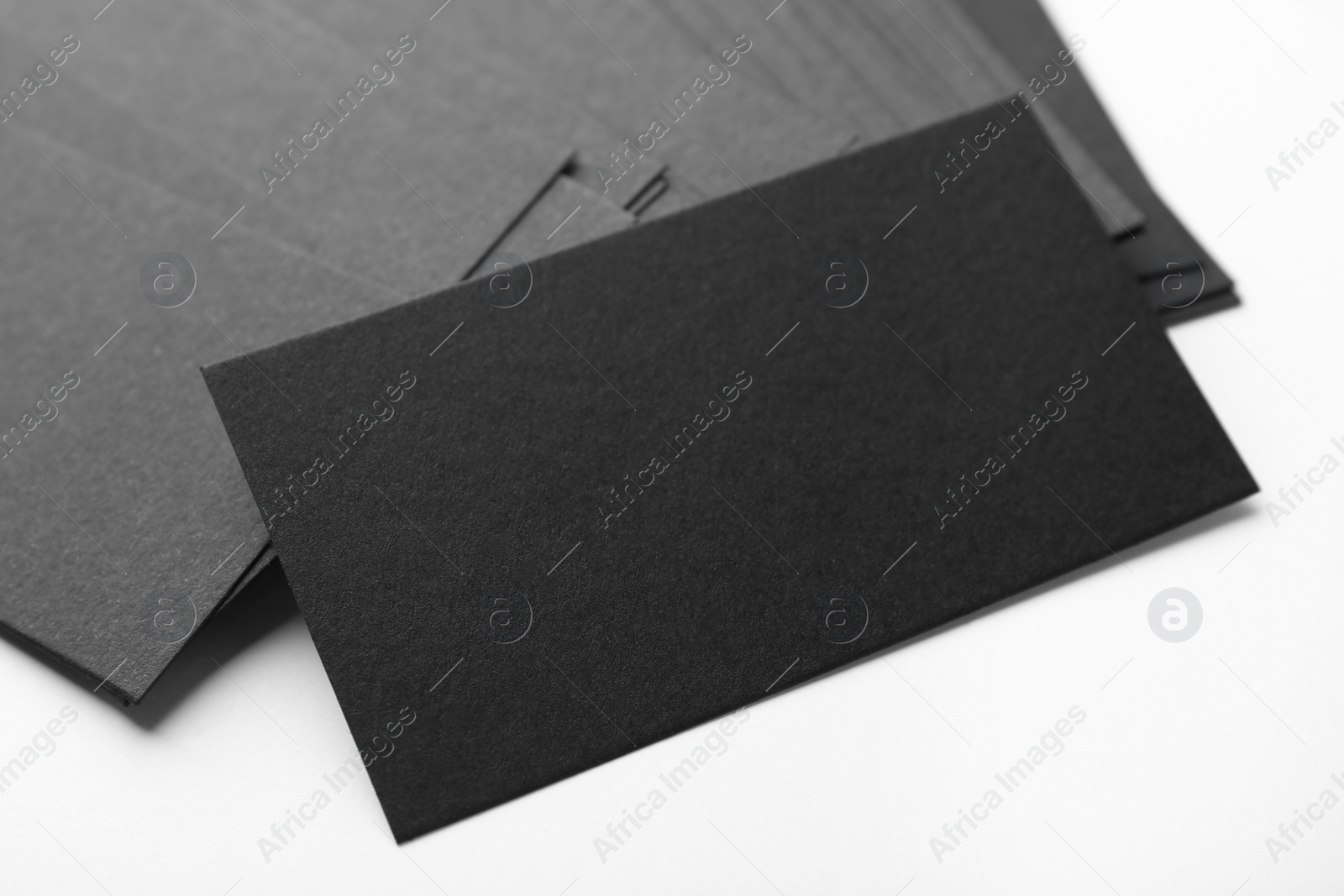 Photo of Blank black business cards on white background, closeup. Mockup for design