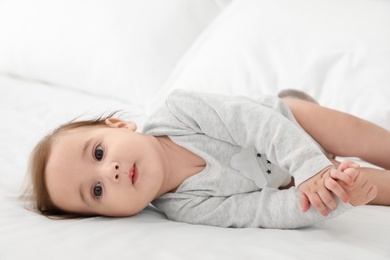 Portrait of adorable baby lying on bed