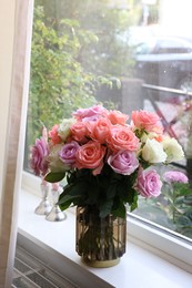 Photo of Vase with beautiful bouquet of roses on windowsill indoors